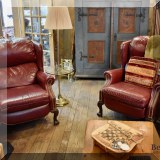 F38. Pair of deep red leather recliners with nailhead trim. 41”h